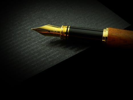 pexels photo 372748 372748 Detailed close-up of a classic fountain pen nib on textured black paper, showcasing elegance.